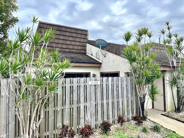 view of side of home with stucco siding and a fenced front yard