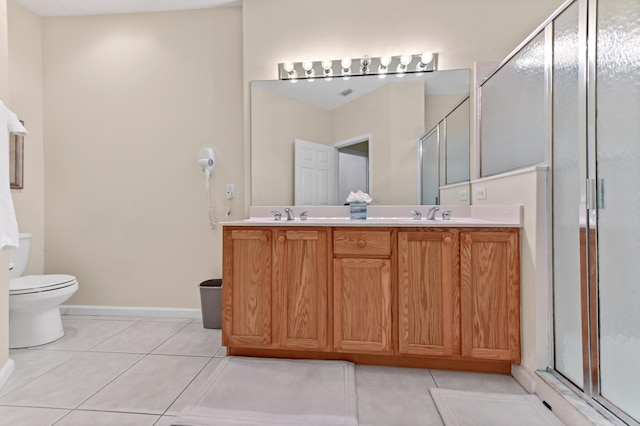 bathroom featuring vanity, toilet, tile patterned flooring, and an enclosed shower