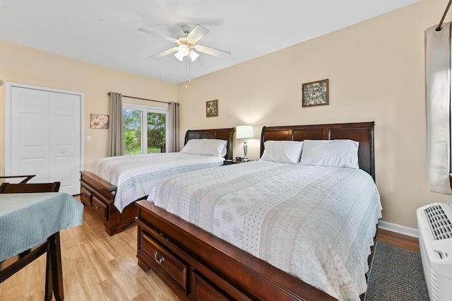 bedroom with a closet, light hardwood / wood-style floors, and ceiling fan