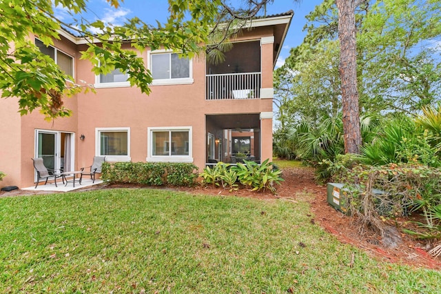 rear view of house with a patio area and a yard