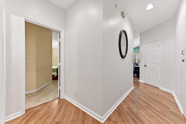 hallway with light hardwood / wood-style floors