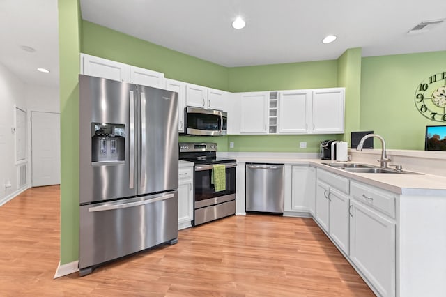 kitchen with sink, white cabinets, and appliances with stainless steel finishes