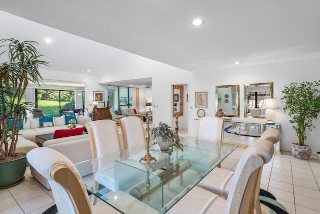 tiled dining room with lofted ceiling and a textured ceiling