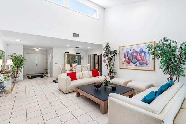 living room with light tile patterned floors and a high ceiling