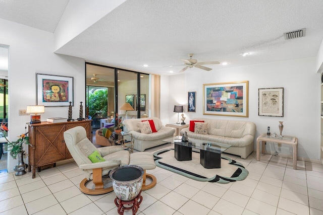 tiled living room featuring ceiling fan and a textured ceiling