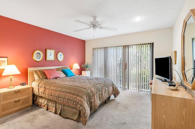 carpeted bedroom with ceiling fan, access to exterior, and a textured ceiling