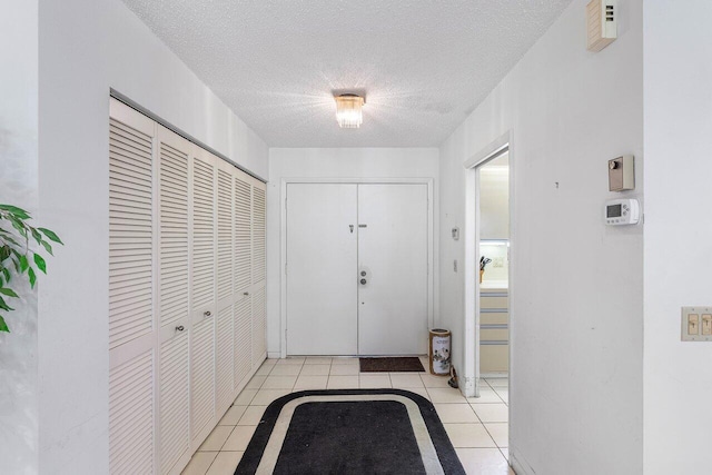 doorway featuring light tile patterned floors and a textured ceiling