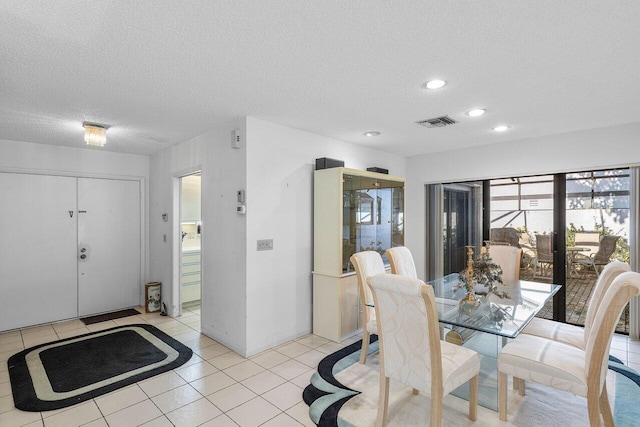 dining room with light tile patterned flooring and a textured ceiling