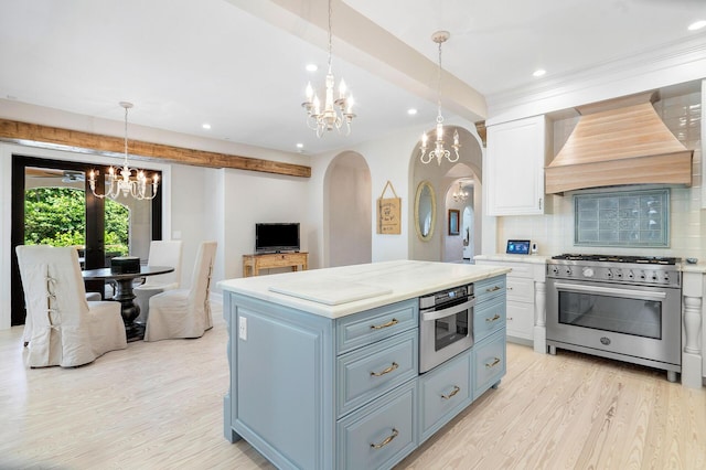 kitchen featuring white cabinets, custom range hood, a kitchen island, high end stainless steel range oven, and light countertops