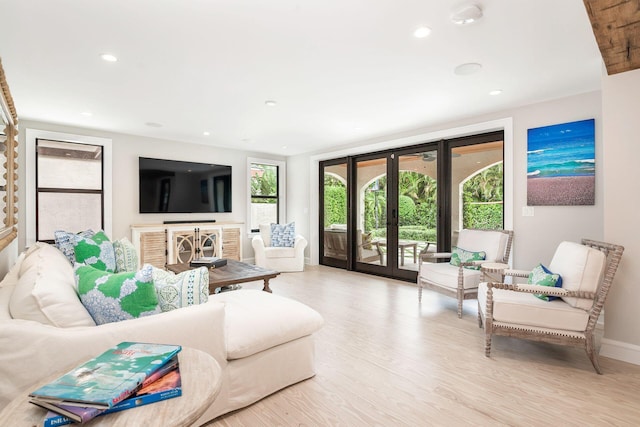 living area featuring recessed lighting, french doors, a healthy amount of sunlight, and light wood finished floors