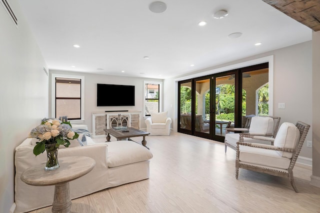 living room featuring recessed lighting, french doors, visible vents, and light wood-style flooring