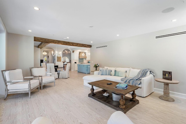 living room featuring a chandelier, light wood-type flooring, baseboards, and recessed lighting