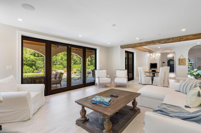 living room featuring arched walkways, recessed lighting, french doors, light wood-type flooring, and beamed ceiling