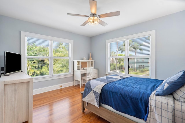 bedroom featuring a ceiling fan, baseboards, and wood finished floors