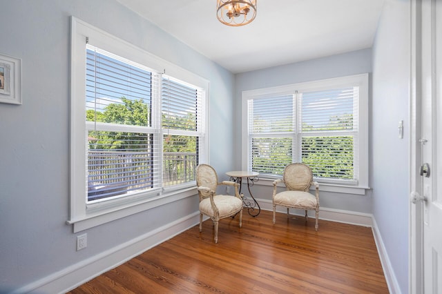 living area with a healthy amount of sunlight, baseboards, and wood finished floors