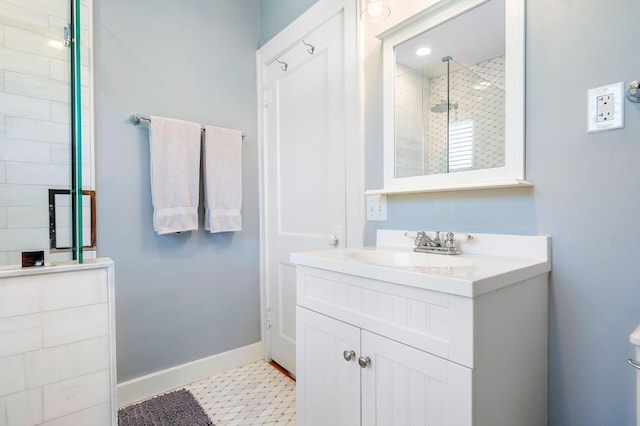 bathroom featuring tile patterned floors, a shower stall, vanity, and baseboards