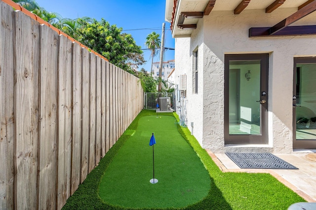 view of yard with a fenced backyard and central AC unit