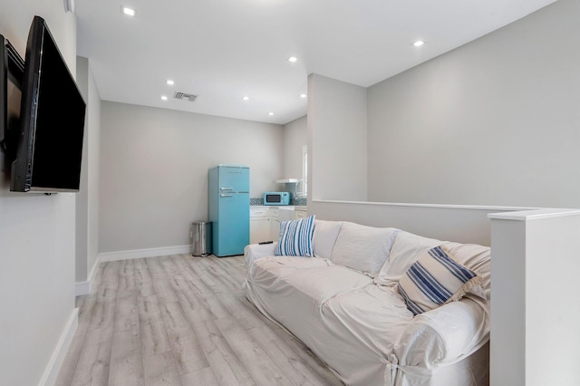 living room with light wood-type flooring, baseboards, visible vents, and recessed lighting