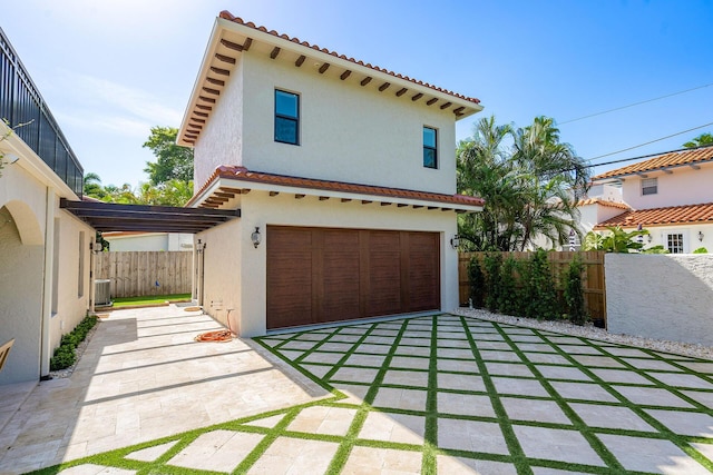 mediterranean / spanish house with central air condition unit, fence, and stucco siding