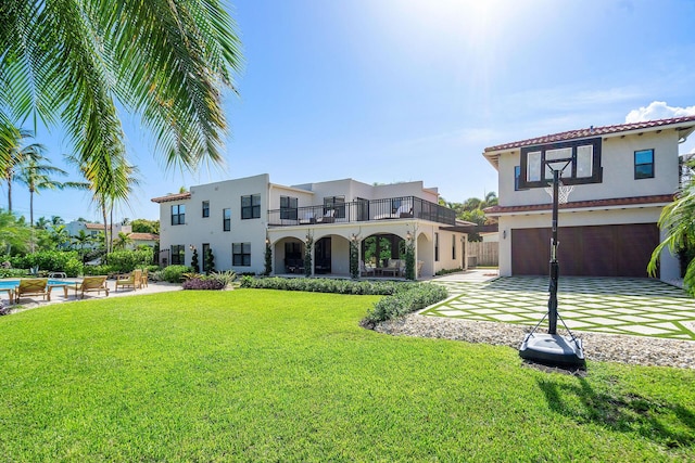 back of property with a garage, a lawn, and stucco siding