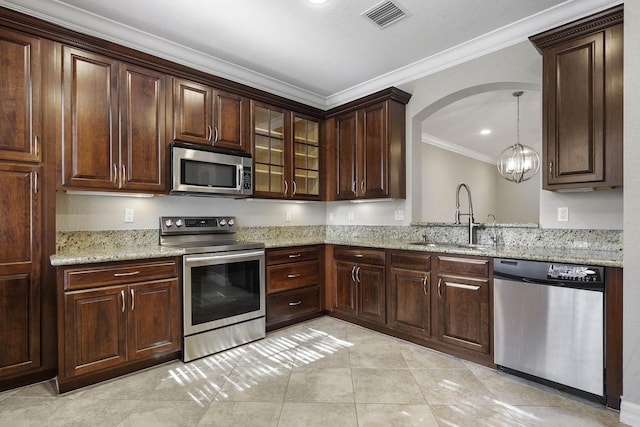 kitchen featuring light stone counters, stainless steel appliances, crown molding, sink, and a chandelier