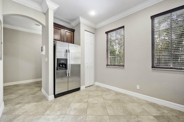 kitchen with stainless steel fridge, dark brown cabinets, plenty of natural light, and light tile patterned flooring