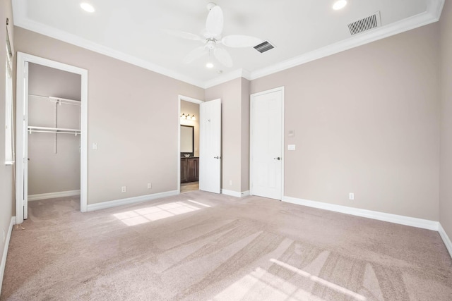 unfurnished bedroom with ensuite bathroom, light colored carpet, ceiling fan, crown molding, and a closet