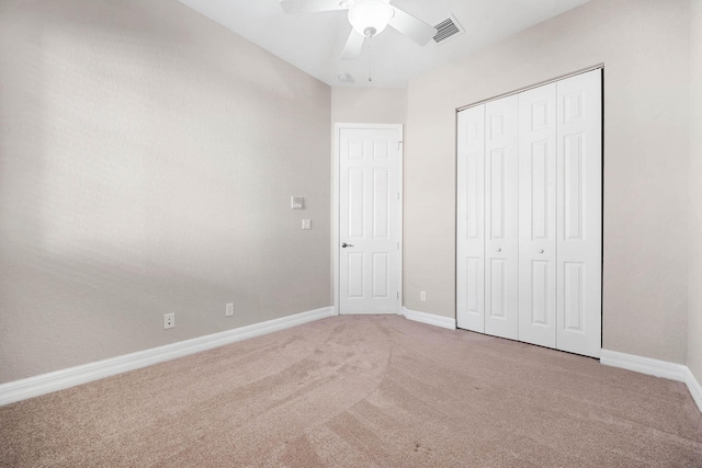 unfurnished bedroom featuring carpet, a closet, and ceiling fan