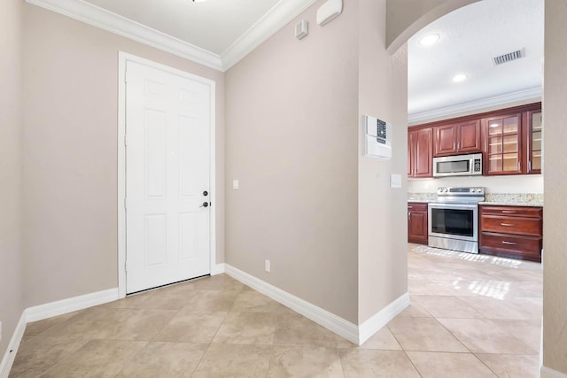 kitchen featuring light tile patterned floors, crown molding, and appliances with stainless steel finishes