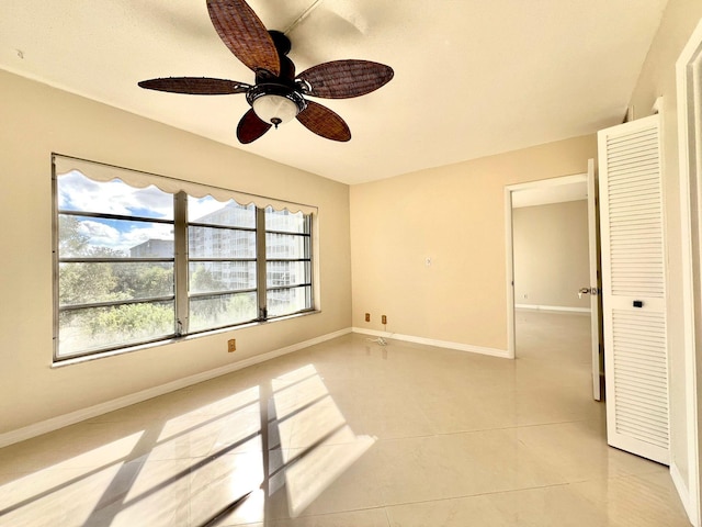 tiled empty room with ceiling fan