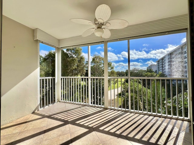 unfurnished sunroom with ceiling fan and a wealth of natural light