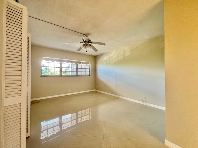 unfurnished room featuring tile patterned floors and ceiling fan