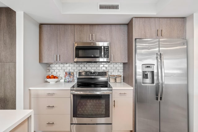 kitchen with decorative backsplash, appliances with stainless steel finishes, and light brown cabinets