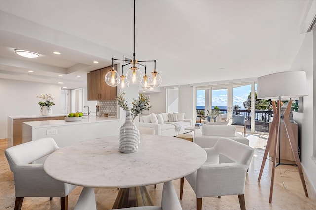 dining area featuring sink and an inviting chandelier