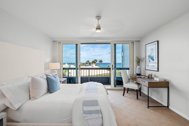 bedroom with access to exterior, ceiling fan, a water view, and multiple windows