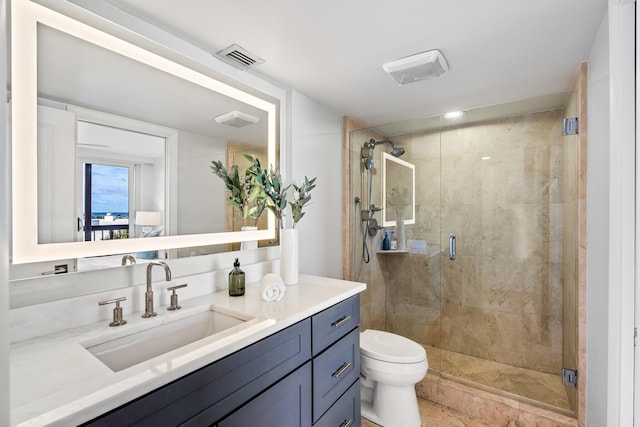 bathroom featuring a shower with door, vanity, and toilet