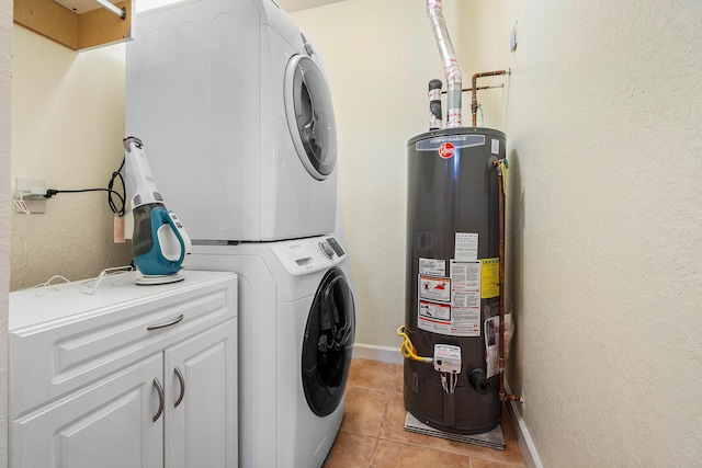 washroom featuring stacked washer and dryer, light tile patterned floors, cabinets, and gas water heater