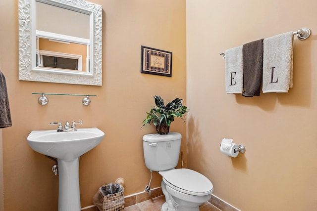 bathroom featuring tile patterned flooring, toilet, and sink