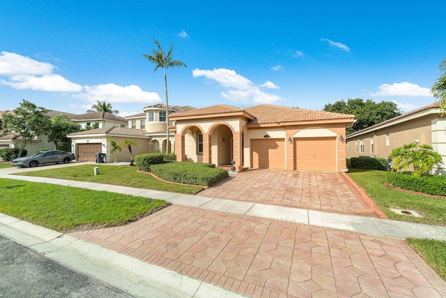 mediterranean / spanish house with a garage and a front lawn