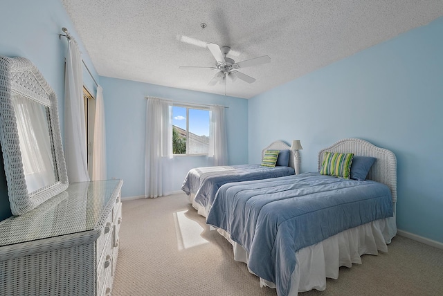 carpeted bedroom with ceiling fan and a textured ceiling