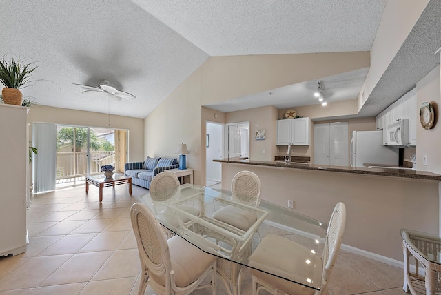 tiled dining room featuring ceiling fan and lofted ceiling