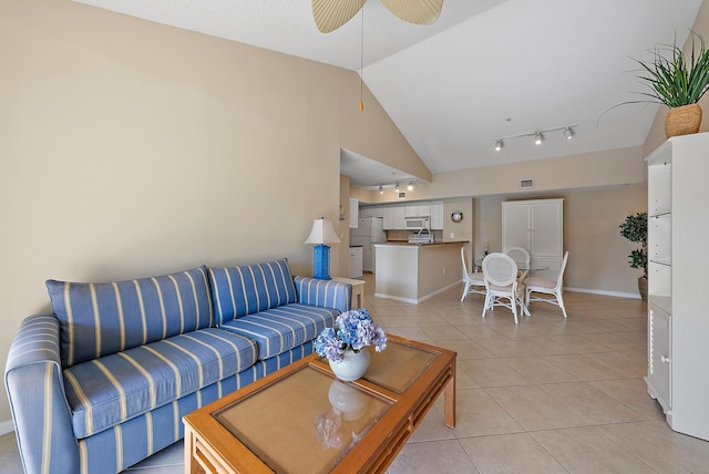 living room with ceiling fan, lofted ceiling, and light tile patterned floors