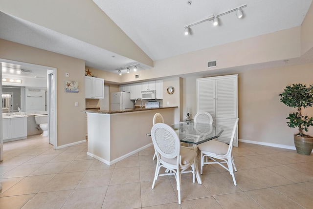 dining area featuring light tile patterned floors, a textured ceiling, and sink