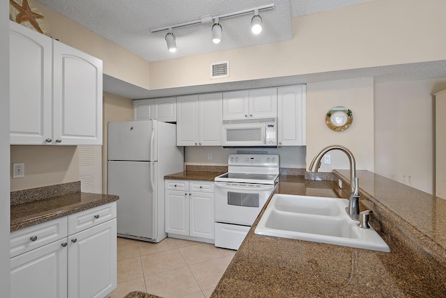 kitchen featuring a textured ceiling, white cabinetry, white appliances, and sink