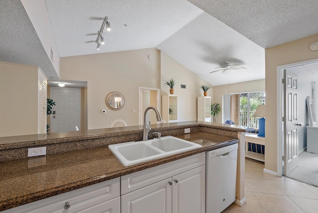 kitchen with dishwasher, lofted ceiling, white cabinets, sink, and ceiling fan