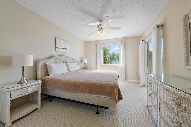 carpeted bedroom featuring ceiling fan and a textured ceiling