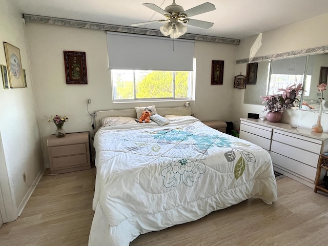 bedroom with ceiling fan, light wood-type flooring, and multiple windows