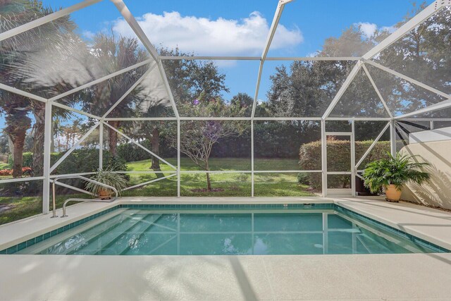 view of pool featuring glass enclosure, ceiling fan, and a patio area