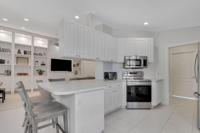 kitchen featuring white cabinetry, sink, light tile patterned floors, and appliances with stainless steel finishes