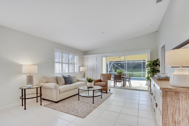 living room featuring light tile patterned floors, lofted ceiling, and a healthy amount of sunlight